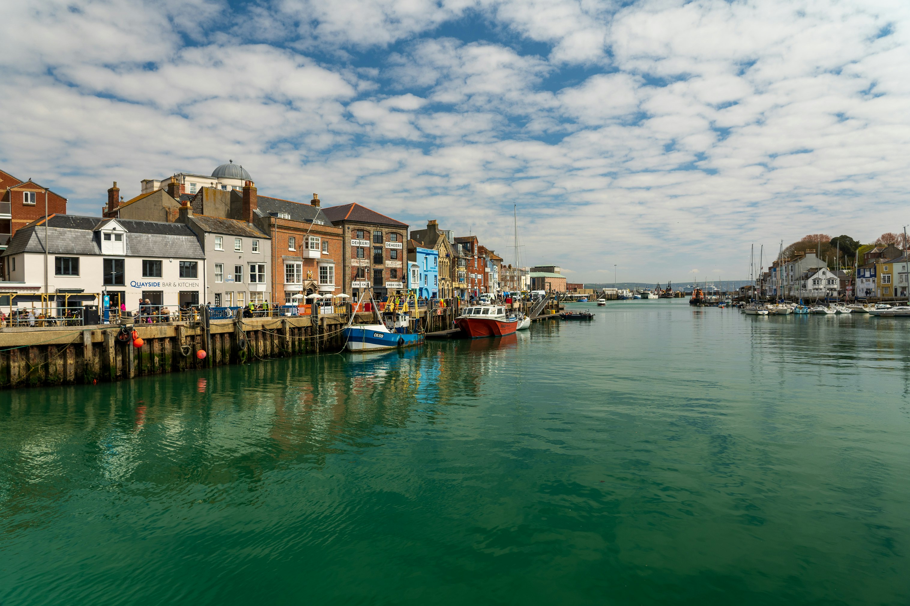 boat on water near houses under cloudy sky during daytime